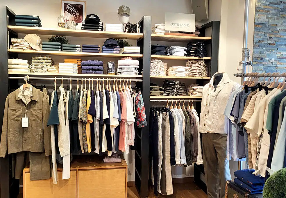 A beige button-up shirt with a subtle texture, displayed on a mannequin in a well-organized clothing store.